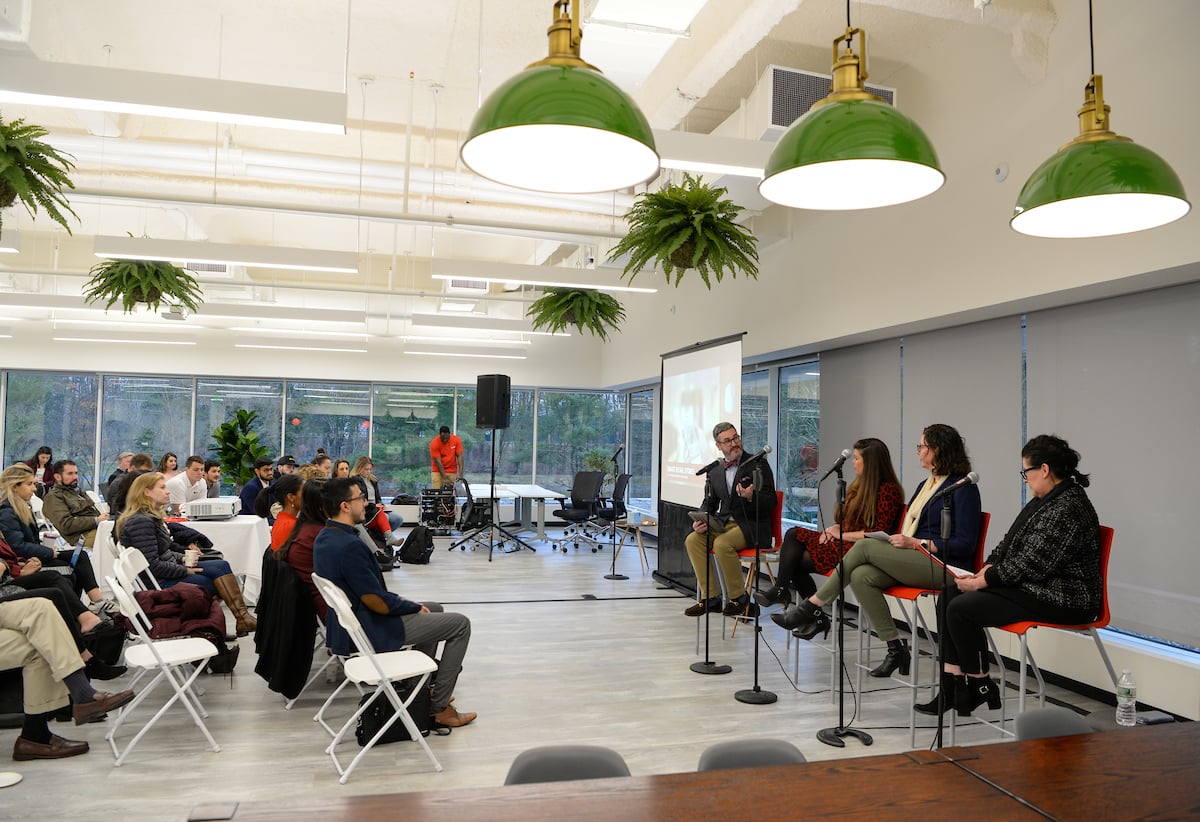 students listening to professors give a panel discussion