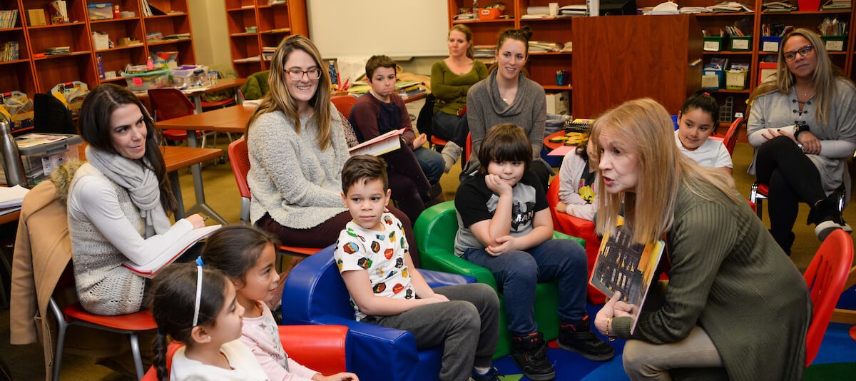 woman reading a story to young children